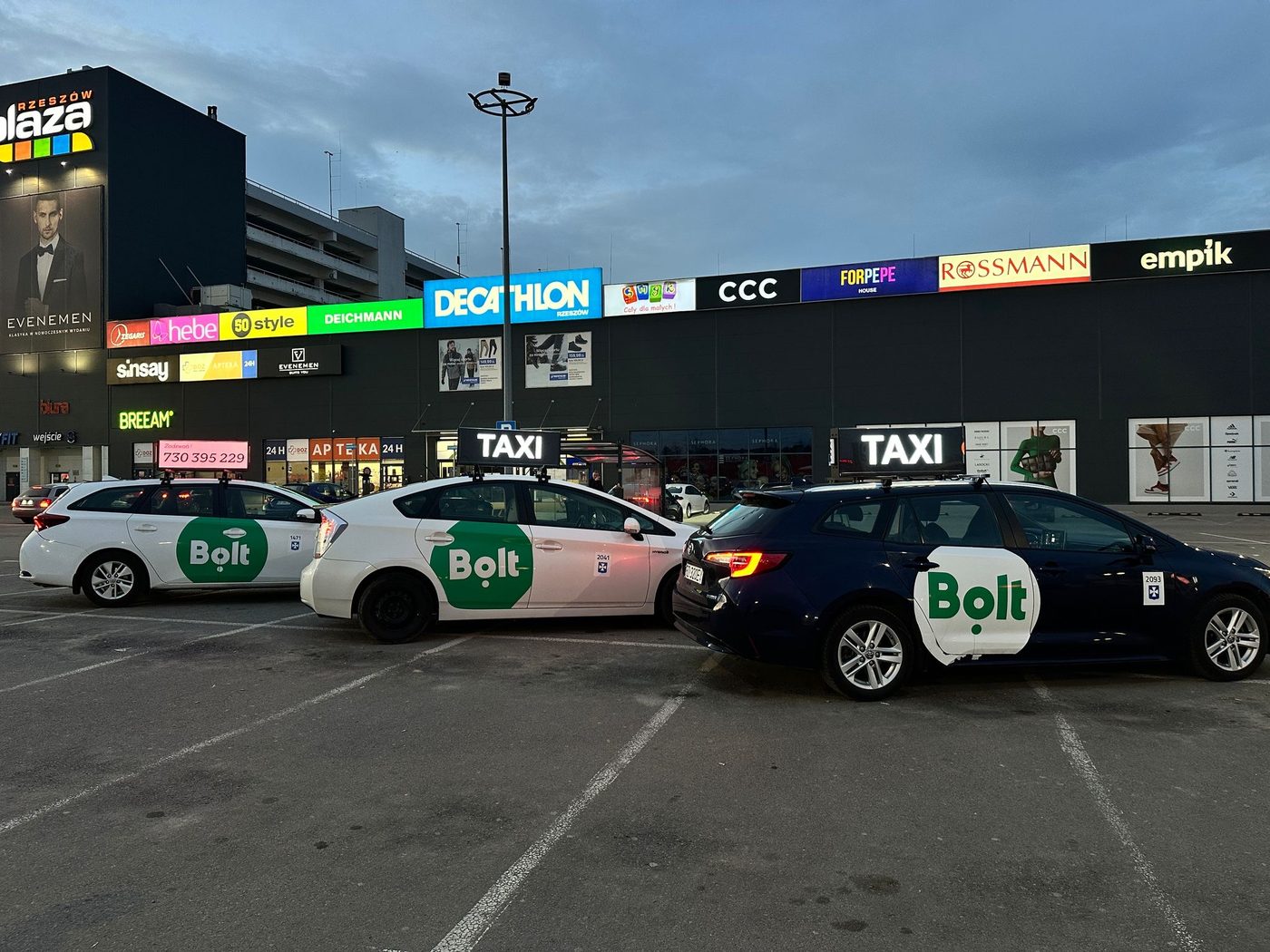 Taksówki z ekranami LED na parkingu przy galerii handlowej
