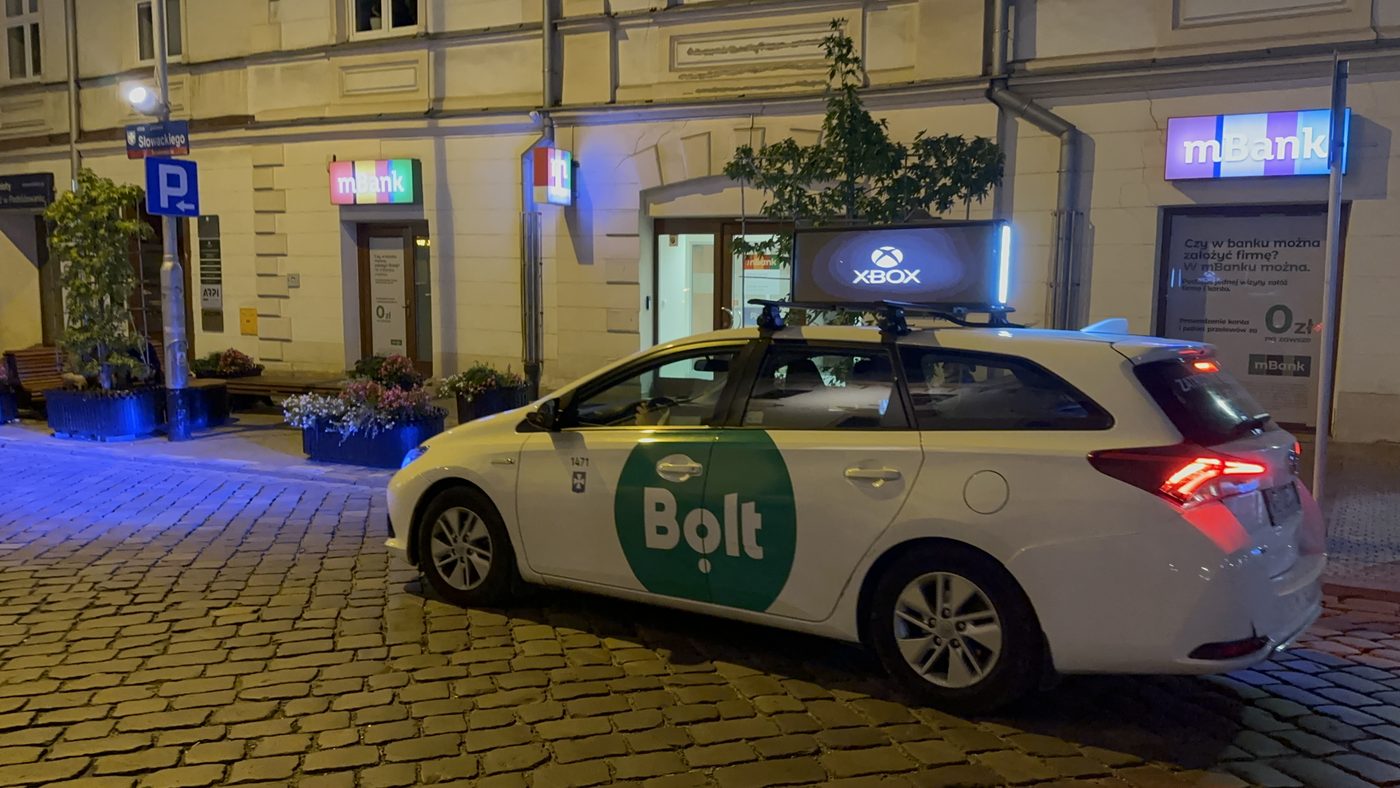 Taxi z ekranem LED w nocnym ruchu miasta
